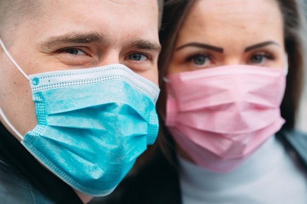 Retrato de um casal com máscaras médicas.