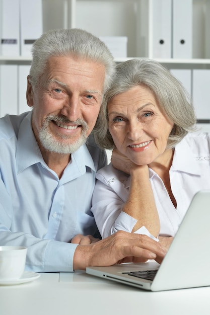 Retrato de um casal de idosos com um laptop