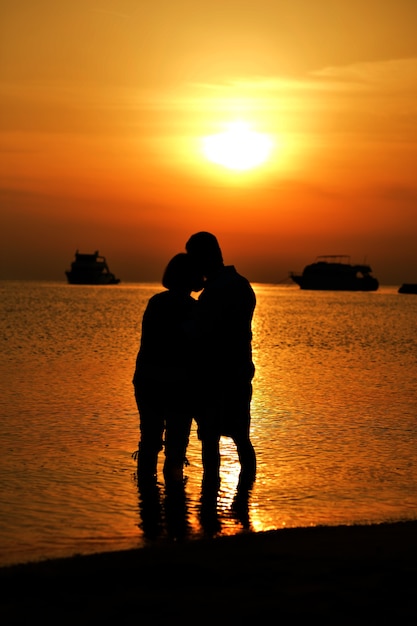 Foto retrato de um casal de idosos no mar ao pôr do sol