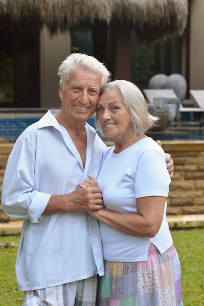 Retrato de um casal de idosos relaxando perto de um hotel resort