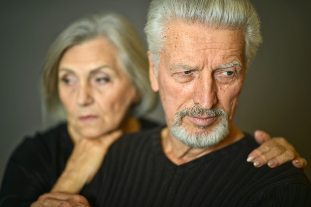 Foto retrato de um casal de idosos tristes em casa
