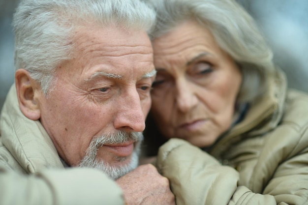 Retrato de um casal de idosos tristes no parque outono