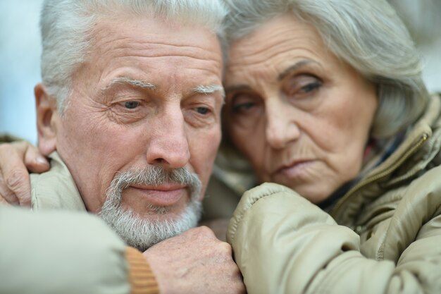 Retrato de um casal de idosos tristes no parque outono