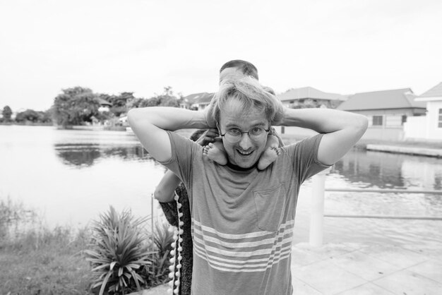 Foto retrato de um casal de pé ao lado do lago contra o céu