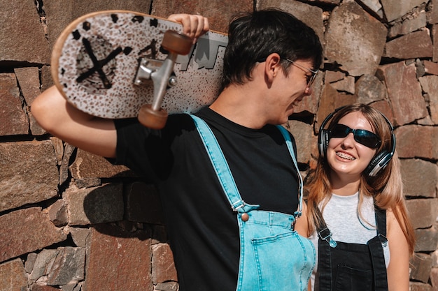 Retrato de um casal feliz de skatistas no parque.