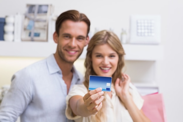 Retrato de um casal feliz mostrando seu novo cartão de crédito