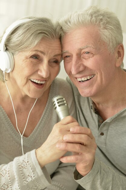 Retrato de um casal idoso com fones de ouvido e microfone