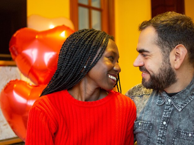 Foto retrato de um casal interracial se beijando em um gesto romântico enquanto aproveita o dia dos namorados.