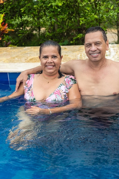 Retrato de um casal latino em uma piscina durante as férias