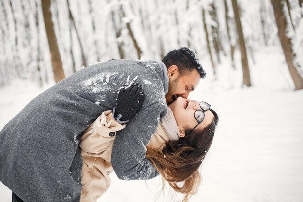 Retrato de um casal romântico passando tempo juntos na floresta de inverno