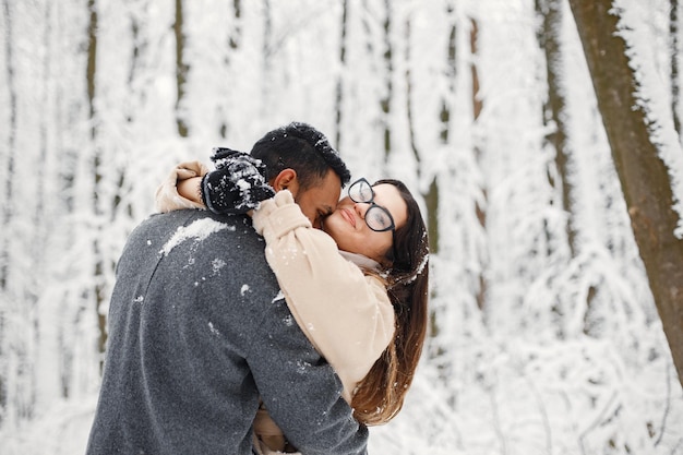 Retrato de um casal romântico passando tempo juntos na floresta de inverno