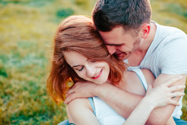 Retrato de um casal se abraçando e amando na grama