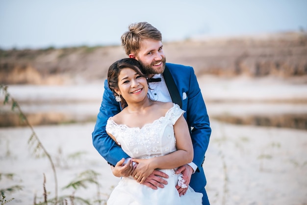Retrato de um casal sorridente abraçando-se enquanto está de pé ao ar livre