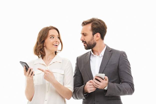 Retrato de um casal sorridente de empresários segurando um celular