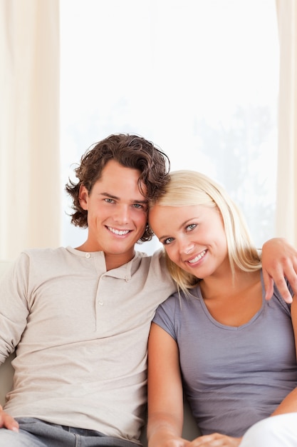 Retrato de um casal sorridente sentado em um sofá