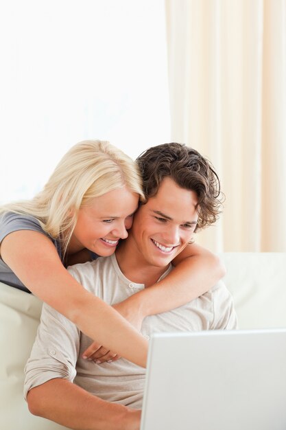 Retrato de um casal sorridente usando um laptop
