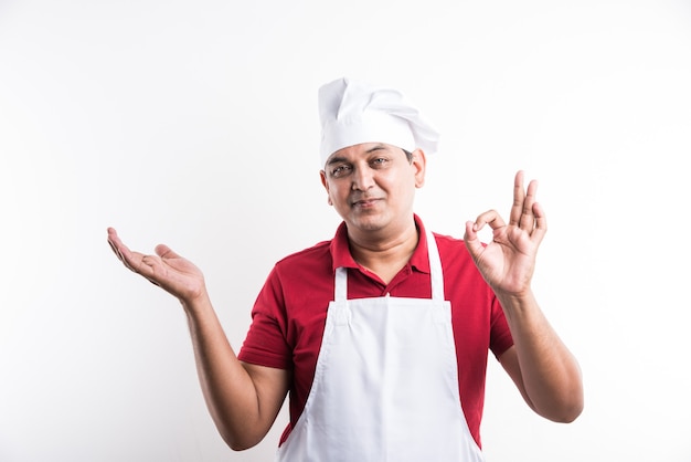 Retrato de um chef indiano bonito posando enquanto realiza atividades