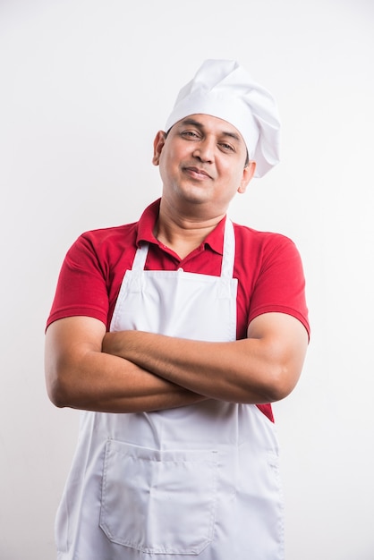 Retrato de um chef indiano bonito posando enquanto realiza atividades