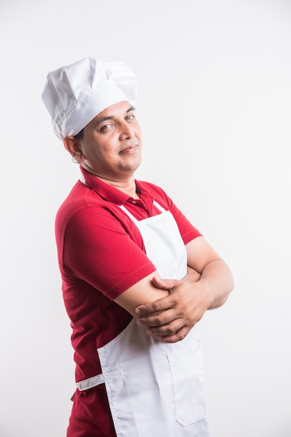 Retrato de um chef indiano bonito posando enquanto realiza atividades