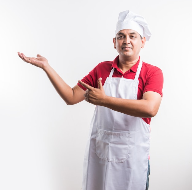 Retrato de um chef indiano bonito posando enquanto realiza atividades