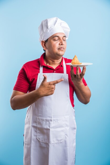 Foto retrato de um chef indiano bonito posando enquanto realiza atividades