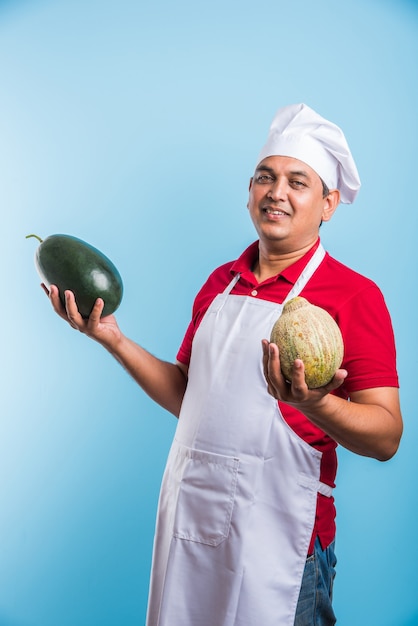 Retrato de um chef indiano bonito posando enquanto realiza atividades