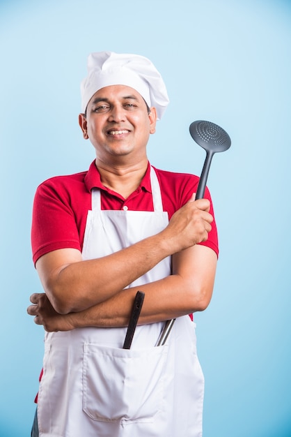 Retrato de um chef indiano bonito posando enquanto realiza atividades