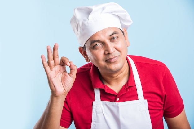 Retrato de um chef indiano bonito posando enquanto realiza atividades