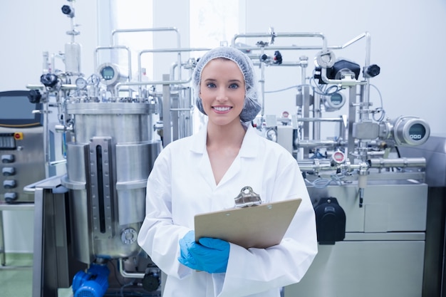 Retrato de um cientista sorridente segurando uma prancheta