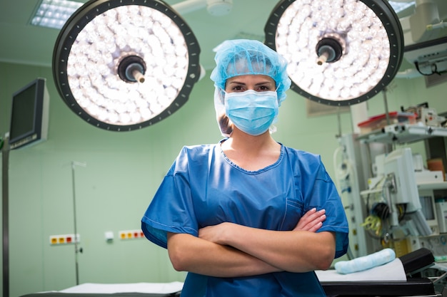 Retrato de um cirurgião feminino em pé na sala de operação