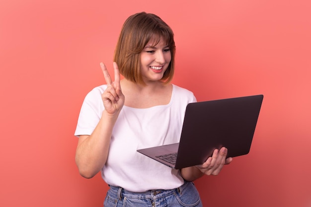 Retrato de um corretor de agente de garota alegre e atraente usando a realização de regozijo de laptop