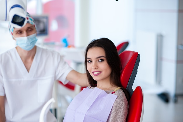 Retrato de um dentista e uma linda garota na odontologia.