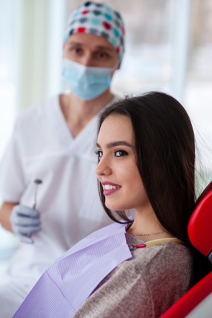 Retrato de um dentista e uma linda garota na odontologia.