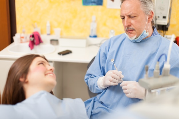 Retrato de um dentista falando com um paciente. Profundidade de campo rasa, foco no homem