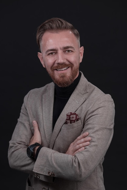 Retrato de um elegante elegante empresário sênior com barba e roupas de negócios casuais em estúdio fotográfico isolado em fundo escuro, gesticulando com as mãos. foto de alta qualidade