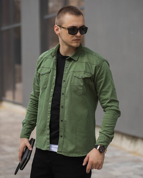 Retrato de um empresário adulto de sucesso com uma camisa verde e um relógio caro