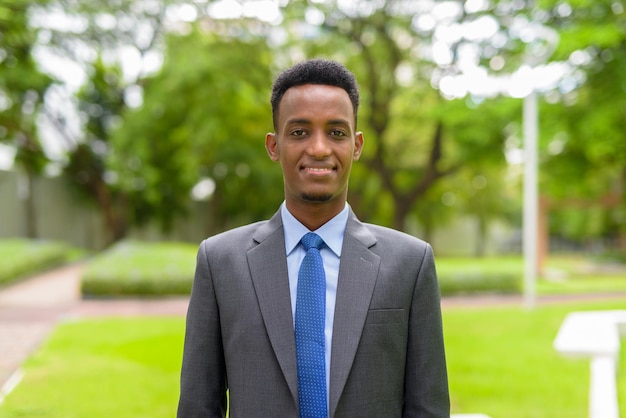 Retrato de um empresário africano bonito de terno e gravata no parque ao ar livre