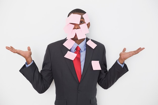 Foto retrato de um empresário afro coberto de notas em branco