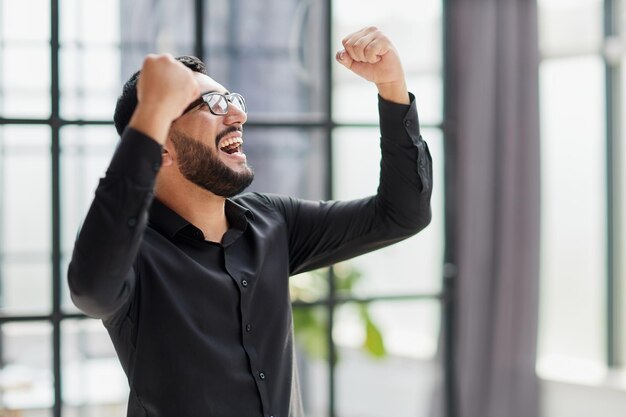 Foto retrato de um empresário alegre comemorando seu sucesso