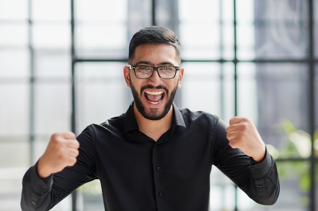 Retrato de um empresário alegre comemorando seu sucesso