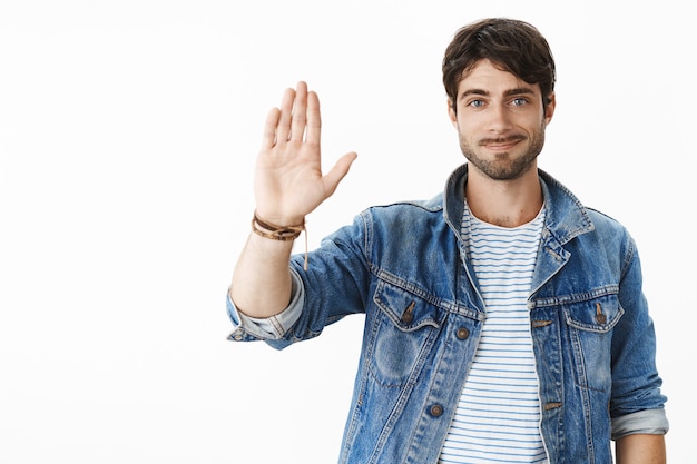 Retrato de um empresário alegre e simpático, simpático e simpático, com bigode e olhos azuis erguendo a palma da mão para dizer olá ou agradecer o bom trabalho da equipe