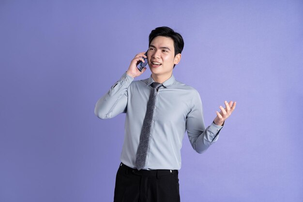 Retrato de um empresário asiático posando em fundo roxo