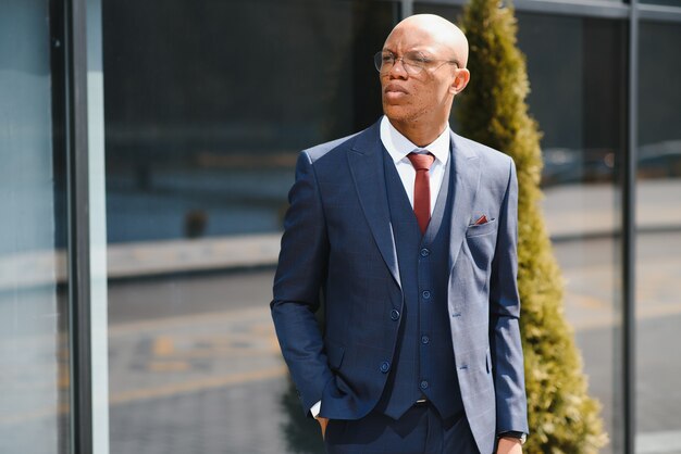 Foto retrato de um empresário bonitão caminhando em um ambiente de negócios