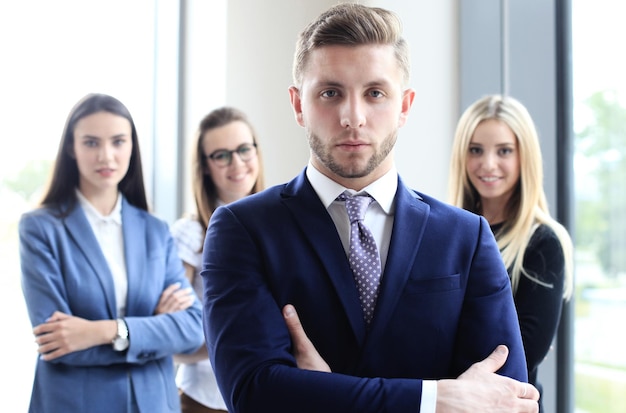 Retrato de um empresário bonitão na frente de sua equipe