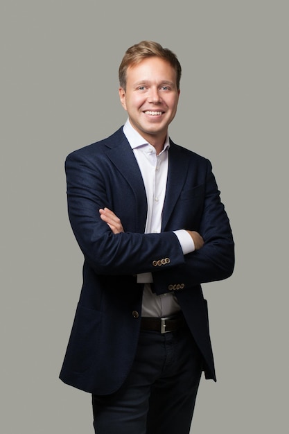 Retrato de um empresário confiante de pé contra um fundo cinzento