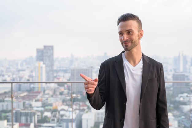 Retrato de um empresário de pé no telhado de um arranha-céu