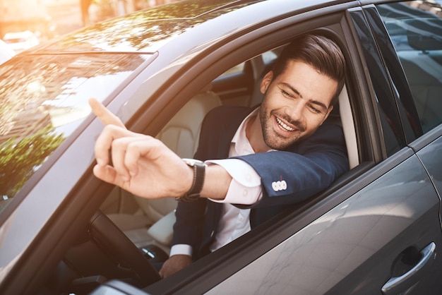 Retrato de um empresário dirigindo um carro e sorrindo em seu trajeto matinal para o trabalho jovem