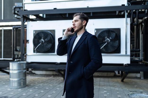 Retrato de um empresário europeu confiante falando ao telefone no contexto de um escritório