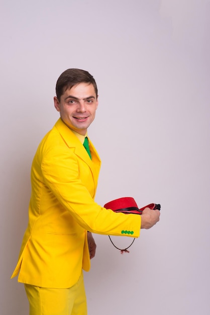 Retrato de um empresário feliz e confiante em terno amarelo e gravata, isolado contra um fundo branco.