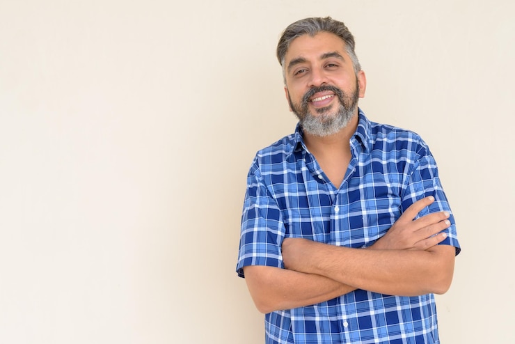 Foto retrato de um empresário indiano barbudo bonito contra um fundo simples